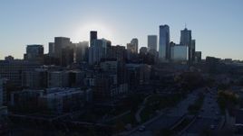 5.7K aerial stock footage flyby the rising sun behind the city skyline in Downtown Denver, Colorado Aerial Stock Footage | DX0001_001630