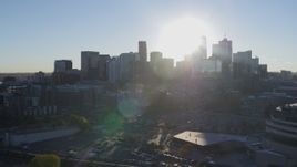5.7K aerial stock footage flyby arena to focus on sun behind city's skyline at sunrise in Downtown Denver, Colorado Aerial Stock Footage | DX0001_001632