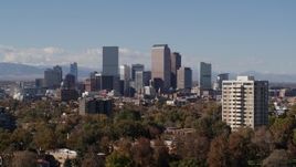5.7K aerial stock footage descend while focusing on the city's skyline with mountains in distance, Downtown Denver, Colorado Aerial Stock Footage | DX0001_001743