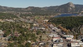 5.7K aerial stock footage a view of shops lining road through Estes Park, Colorado lake and mountains in distance Aerial Stock Footage | DX0001_001999