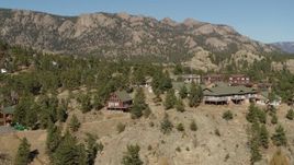 5.7K aerial stock footage orbiting rural hillside homes near rugged mountains in Estes Park, Colorado Aerial Stock Footage | DX0001_002004