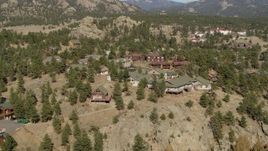 5.7K aerial stock footage flying away from rural hillside homes near rugged mountains in Estes Park, Colorado Aerial Stock Footage | DX0001_002006