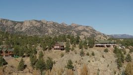 5.7K aerial stock footage of a view of rural hillside homes near rugged mountains during descent in Estes Park, Colorado Aerial Stock Footage | DX0001_002008