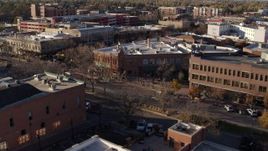 5.7K aerial stock footage of flying by brick office buildings and street level shop in Fort Collins, Colorado Aerial Stock Footage | DX0001_002043