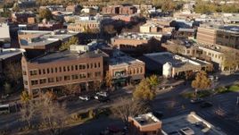5.7K aerial stock footage people and cars passing a shop with green awning and brick office building in Fort Collins, Colorado Aerial Stock Footage | DX0001_002059
