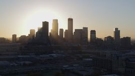5.7K aerial stock footage flying by the rising sun behind the city skyline in Downtown Minneapolis, Minnesota Aerial Stock Footage | DX0001_002081