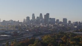 5.7K aerial stock footage ascend from behind trees to reveal skyline at sunrise in Downtown Minneapolis, Minnesota Aerial Stock Footage | DX0001_002090