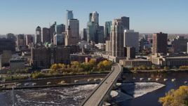 5.7K aerial stock footage slowly passing by the skyline, seen from a bridge spanning the river in Downtown Minneapolis, Minnesota Aerial Stock Footage | DX0001_002137
