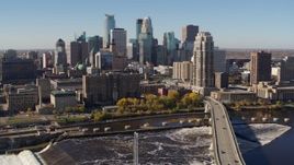 5.7K aerial stock footage passing by the skyline, seen from a bridge spanning the river in Downtown Minneapolis, Minnesota Aerial Stock Footage | DX0001_002138