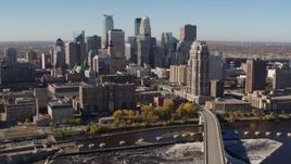 5.7K aerial stock footage flying by the skyline, seen from a bridge spanning the river in Downtown Minneapolis, Minnesota Aerial Stock Footage | DX0001_002139