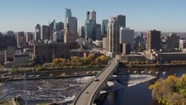 5.7K aerial stock footage descend near a bridge spanning the river with a view of the skyline, Downtown Minneapolis, Minnesota Aerial Stock Footage | DX0001_002142