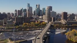 5.7K aerial stock footage descend by a bridge spanning the river for stationary view of the skyline, Downtown Minneapolis, Minnesota Aerial Stock Footage | DX0001_002146