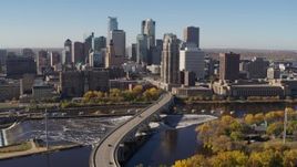 5.7K aerial stock footage ascend by a bridge spanning the river while flying away from the skyline, Downtown Minneapolis, Minnesota Aerial Stock Footage | DX0001_002147