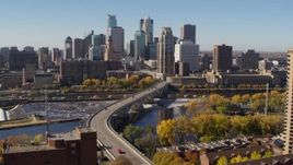 5.7K aerial stock footage descend near a bridge spanning the river with view of the skyline, Downtown Minneapolis, Minnesota Aerial Stock Footage | DX0001_002148
