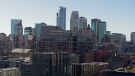 5.7K aerial stock footage descend by office building and construction, city's skyline in background, Downtown Minneapolis, Minnesota Aerial Stock Footage | DX0001_002164