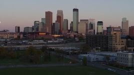 5.7K aerial stock footage reverse view of city's skyline at sunset, seen from park, Downtown Minneapolis, Minnesota Aerial Stock Footage | DX0001_002242