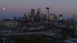 5.7K aerial stock footage of the moon in the sky near the city's downtown skyline at twilight, Downtown Minneapolis, Minnesota Aerial Stock Footage | DX0001_002255