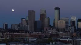 5.7K aerial stock footage of flying by the city's skyline at twilight with moon in the sky, Downtown Minneapolis, Minnesota Aerial Stock Footage | DX0001_002262