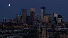 5.7K aerial stock footage flyby the moon above skyscrapers in city skyline at twilight, Downtown Minneapolis, Minnesota Aerial Stock Footage | DX0001_002274
