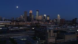 5.7K aerial stock footage flying by market building with the moon above city skyline at twilight, Downtown Minneapolis, Minnesota Aerial Stock Footage | DX0001_002276
