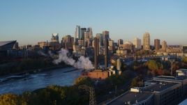 5.7K aerial stock footage ascend to reveal power plant, and the city skyline across the river at sunrise, Downtown Minneapolis, Minnesota Aerial Stock Footage | DX0001_002289