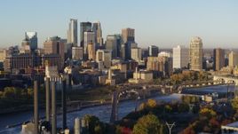 5.7K aerial stock footage of a view of the city skyline across the river at sunrise during descent, Downtown Minneapolis, Minnesota Aerial Stock Footage | DX0001_002305