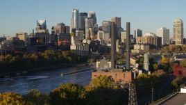 5.7K aerial stock footage descend by riverfront power plant at sunrise, with skyline in background, Downtown Minneapolis, Minnesota Aerial Stock Footage | DX0001_002327