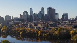 5.7K aerial stock footage of flying by the skyline seen from a park by the river, Downtown Minneapolis, Minnesota Aerial Stock Footage | DX0001_002329