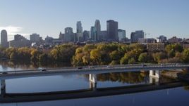 5.7K aerial stock footage of passing by the bridge over river with a view of the skyline of Downtown Minneapolis, Minnesota Aerial Stock Footage | DX0001_002351