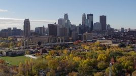 5.7K aerial stock footage ascend from trees to flyby the city's skyline across the river, Downtown Minneapolis, Minnesota Aerial Stock Footage | DX0001_002358