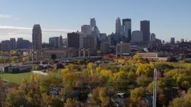 5.7K aerial stock footage descend toward trees to flyby the city's skyline across the river, Downtown Minneapolis, Minnesota Aerial Stock Footage | DX0001_002359