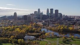 5.7K aerial stock footage flying by the city's skyline across the river, seen from a park, Downtown Minneapolis, Minnesota Aerial Stock Footage | DX0001_002363