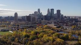 5.7K aerial stock footage approach the city's skyline across the river, seen from a park, Downtown Minneapolis, Minnesota Aerial Stock Footage | DX0001_002364