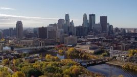 5.7K aerial stock footage approach the city's skyline and bridges spanning the river, seen from a park, Downtown Minneapolis, Minnesota Aerial Stock Footage | DX0001_002365
