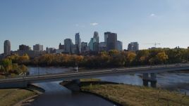 5.7K aerial stock footage white car crossing bridge over river with view of city skyline, Downtown Minneapolis, Minnesota Aerial Stock Footage | DX0001_002449
