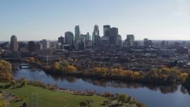 5.7K aerial stock footage wide view of the city skyline, seen while flying by bridge spanning the river, Downtown Minneapolis, Minnesota Aerial Stock Footage | DX0001_002458