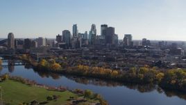 5.7K aerial stock footage of the city skyline seen while flying by a bridge and the river, Downtown Minneapolis, Minnesota Aerial Stock Footage | DX0001_002464