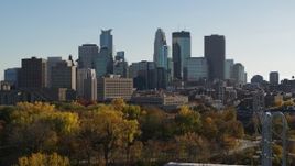 5.7K aerial stock footage focus on the city skyline while descending by trees, Downtown Minneapolis, Minnesota Aerial Stock Footage | DX0001_002482