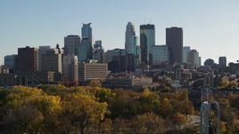 5.7K aerial stock footage descend behind trees and focus on the city skyline, Downtown Minneapolis, Minnesota Aerial Stock Footage | DX0001_002484