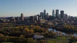 5.7K aerial stock footage descend toward park with view of city skyline across the Mississippi River, Downtown Minneapolis, Minnesota Aerial Stock Footage | DX0001_002497