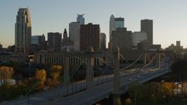 5.7K aerial stock footage passing by Hennepin Avenue Bridge and city skyline at sunset, Downtown Minneapolis, Minnesota Aerial Stock Footage | DX0001_002516