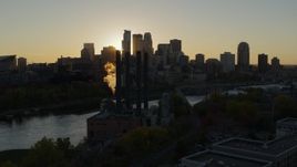 5.7K aerial stock footage of the city skyline across the river while flying by a power plant at sunset, Downtown Minneapolis, Minnesota Aerial Stock Footage | DX0001_002520
