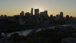 5.7K aerial stock footage of flying by the city skyline across the river at sunset, reveal power plant, Downtown Minneapolis, Minnesota Aerial Stock Footage | DX0001_002522