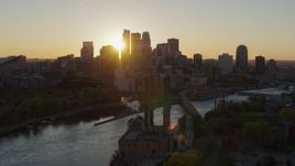 5.7K aerial stock footage flyby riverfront power plant at sunset for view of city skyline, Downtown Minneapolis, Minnesota Aerial Stock Footage | DX0001_002527