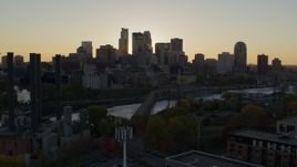 5.7K aerial stock footage view of city skyline while flying by bridge and river at sunset, reveal power plant, Downtown Minneapolis, Minnesota Aerial Stock Footage | DX0001_002529