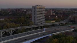 5.7K aerial stock footage of a condo complex seen from a bridge at sunset, Minneapolis, Minnesota Aerial Stock Footage | DX0001_002548