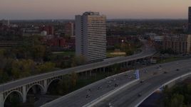 5.7K aerial stock footage of reverse view of a condo complex beside a bridge at sunset, Minneapolis, Minnesota Aerial Stock Footage | DX0001_002549
