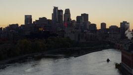 5.7K aerial stock footage of the city's skyline across the river at sunset, seen during ascent, Downtown Minneapolis, Minnesota Aerial Stock Footage | DX0001_002556
