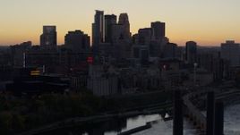 5.7K aerial stock footage of the city's skyline across the river at sunset, reveal a bridge, Downtown Minneapolis, Minnesota Aerial Stock Footage | DX0001_002557