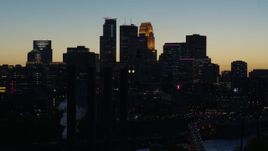 5.7K aerial stock footage pass skyscrapers lit for night in the city skyline at twilight and ascend, Downtown Minneapolis, Minnesota Aerial Stock Footage | DX0001_002579